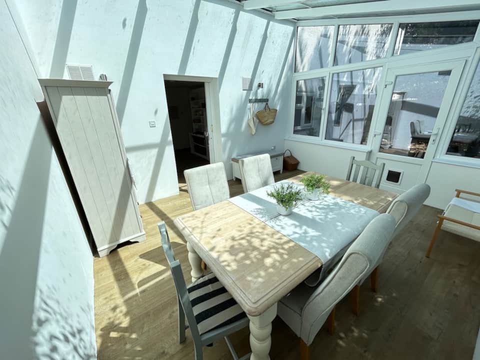 Bright conservatory dining space arranged for holiday guests
